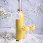 Schritt 1: Puddingmischung vorbereiten Fülle 375 g Haferdrink in den Mixtopf. Entnimm etwa 60 g davon und stelle sie in eine kleine Schüssel zur Seite. Gib das Puddingpulver und den gesiebten Puderzucker in die Schüssel mit den 60 g Haferdrink. Rühre diese Mischung klümpchenfrei mit einem Schneebesen oder Löffel um. Achte darauf, dass keine Klümpchen entstehen! Schritt 2: Haferdrink erhitzen Gib den restlichen Haferdrink (ca. 315 g) zusammen mit ¼ TL Kala Namak und der Kurkuma in den Mixtopf. Koche die Mischung für 4 Minuten, 100°C, Stufe 2, bis sie heiß ist. Schritt 3: Puddingmischung einrühren Reduziere die Temperatur auf 90°C und stelle die Geschwindigkeit auf Stufe 3. Gieße die vorbereitete Puddingmischung langsam durch die Deckelöffnung in den heißen Haferdrink und koche alles zusammen für 3 Minuten, 90°C, Stufe 3, bis die Masse leicht eindickt. Schritt 4: Sahne hinzufügen Nimm die Mischung aus dem Mixtopf (keine Temperatur mehr) und füge die 75 g vegane Sojasahne hinzu. Rühre sie bei Stufe 3, 30 Sekunden unter. Schritt 5: Alkohol einarbeiten Lasse die Mischung 2-3 Minuten abkühlen. Füge 150 g Prima Sprit hinzu und rühre alles bei Stufe 3, 30 Sekunden gründlich um. Schritt 6: Abfüllen und Lagern Fülle den Eierlikör in saubere, sterilisierte Flaschen ab. Lagere ihn kühl und dunkel. Vor dem Servieren gut durchschütteln.